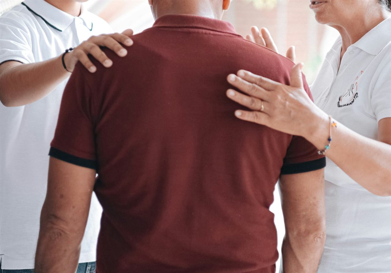 Valutazione posturale: mani appoggiate sulle spalle di una persona